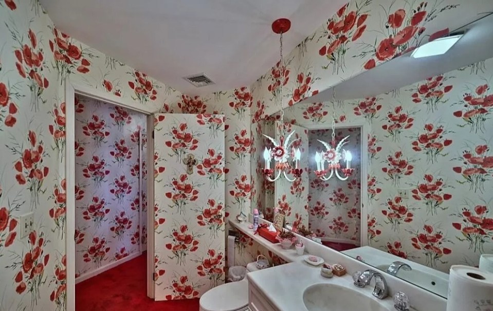 Wallpaper with bright red poppies is seen in the bathrooms