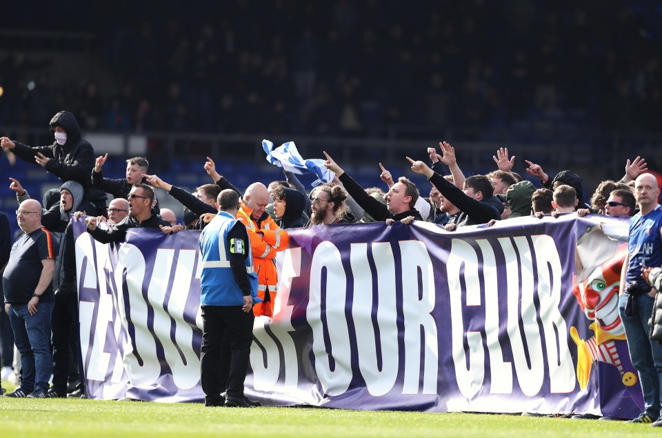 Oldham fans protest the club's owners on the pitch at Boundary Park