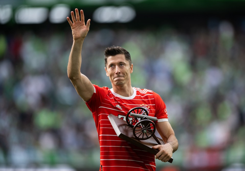 The Pole waves to the crowd as he clutches his Bundesliga top scorer trophy