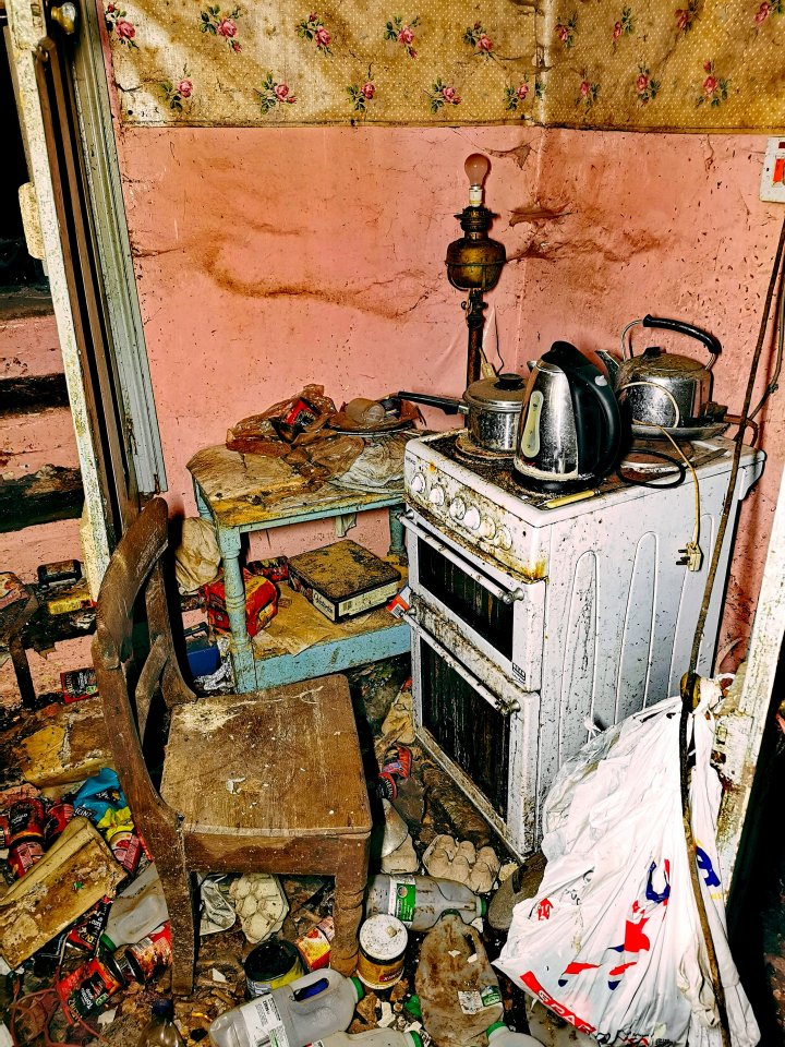 Kettles and saucepans still sit on the old Beko stove and the floor is covered in rubbish