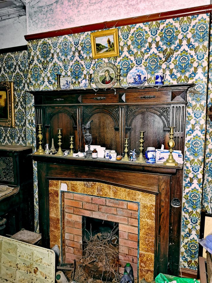 Candlesticks were left above the fireplace, along with creepy pictures on the walls