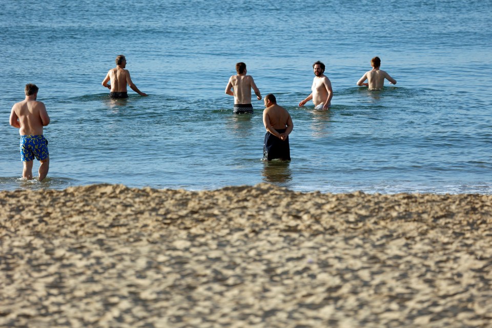 Early morning bathers go for a dip in the sea at Branksome beach, Bournemouth