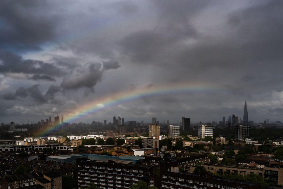 A rainbow appears over London's skyline as a brief morning rainstorm clears