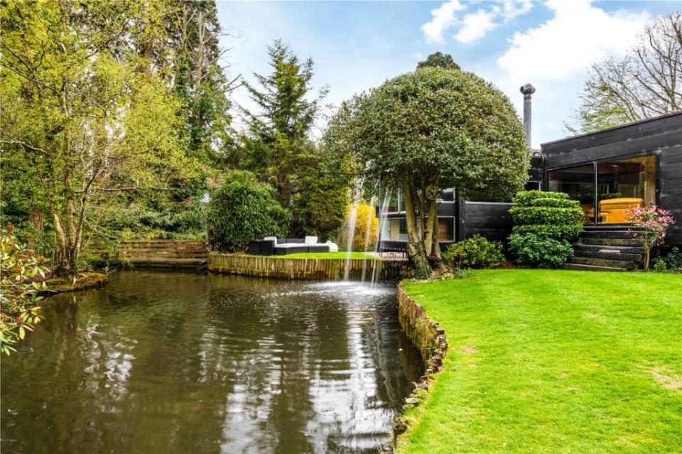 The mansion overlooks a shared lake and manicured gardens