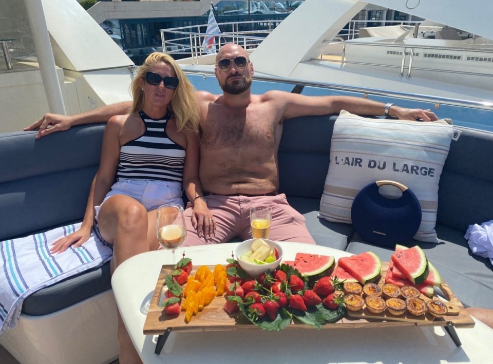 a man and woman sit on a boat with a pillow that says l' air du large