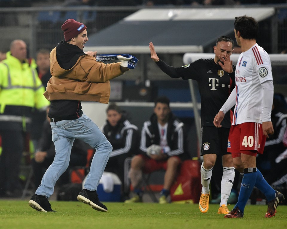 A Hamburg fan attacks Franck Ribery with a scarf