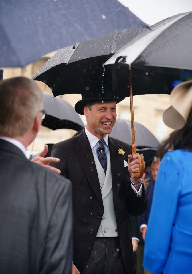 Prince William was all smiles despite the rain as he chatted to guests from beneath his brolly