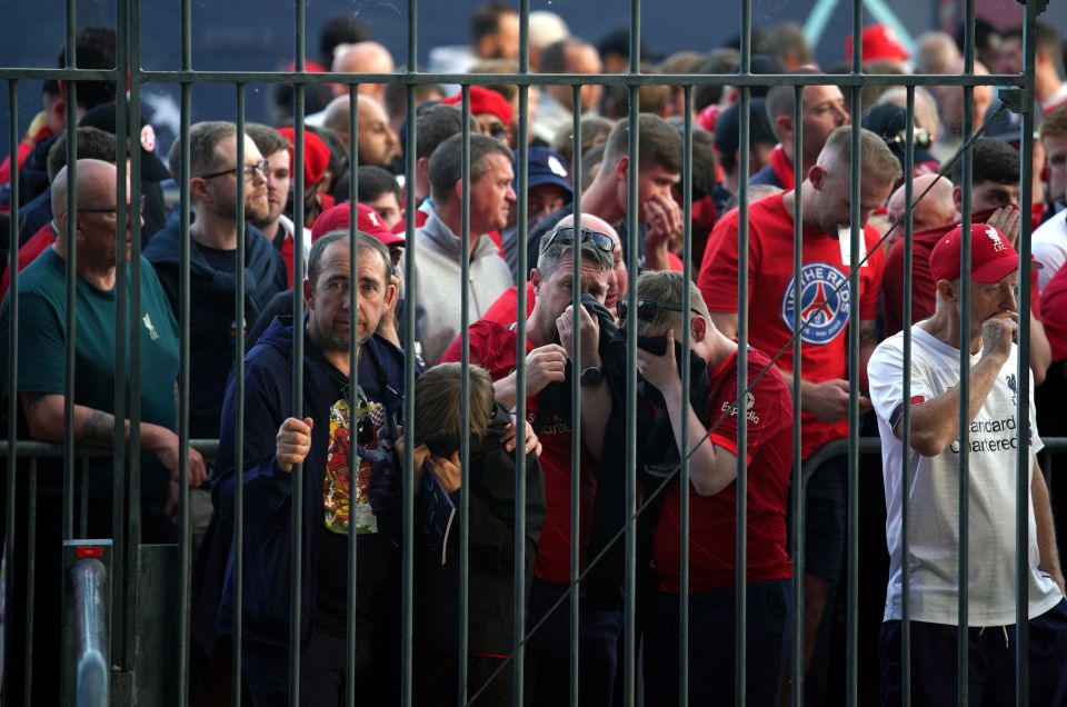 Liverpool fans cover their mouths after being pepper-sprayed by police