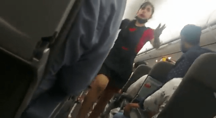 Cabin crew member attempts to reassure passengers during the flight