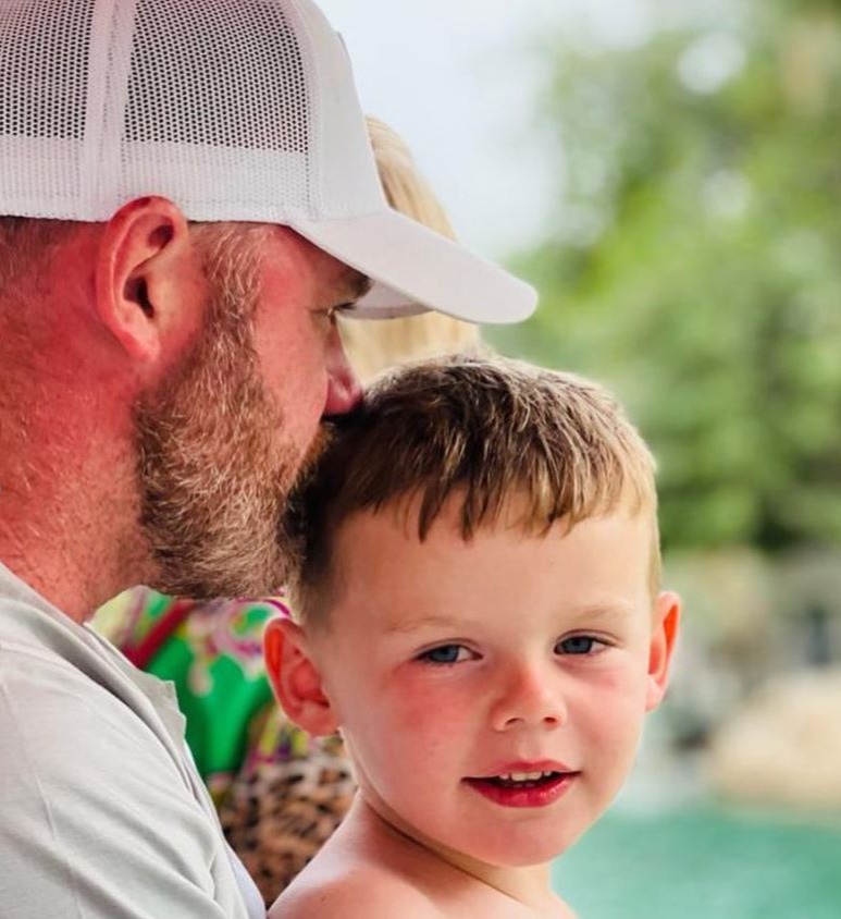 Wayne Rooney kisses one of his sons on the head