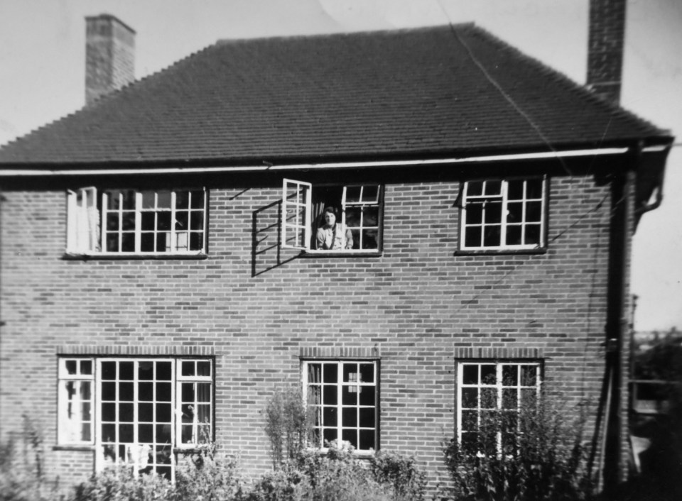 Philip's mum Doris looks out of an upstairs window in 1953