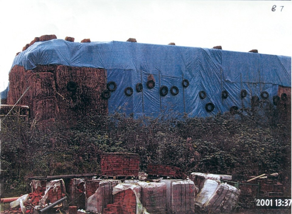 The crafty farmer hid the entire construction behind a massive blue tarpaulin, tyres and stacks of hay bales