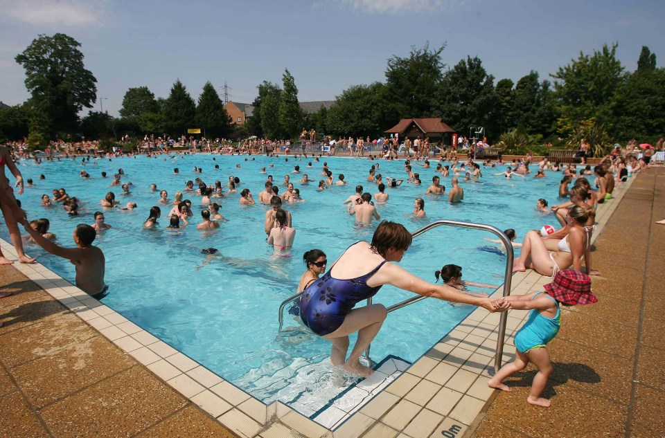 a woman helps a little girl get out of a swimming pool