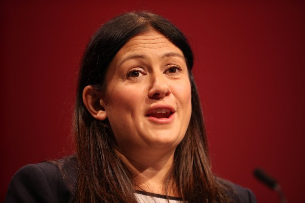 a woman speaking into a microphone with a red background