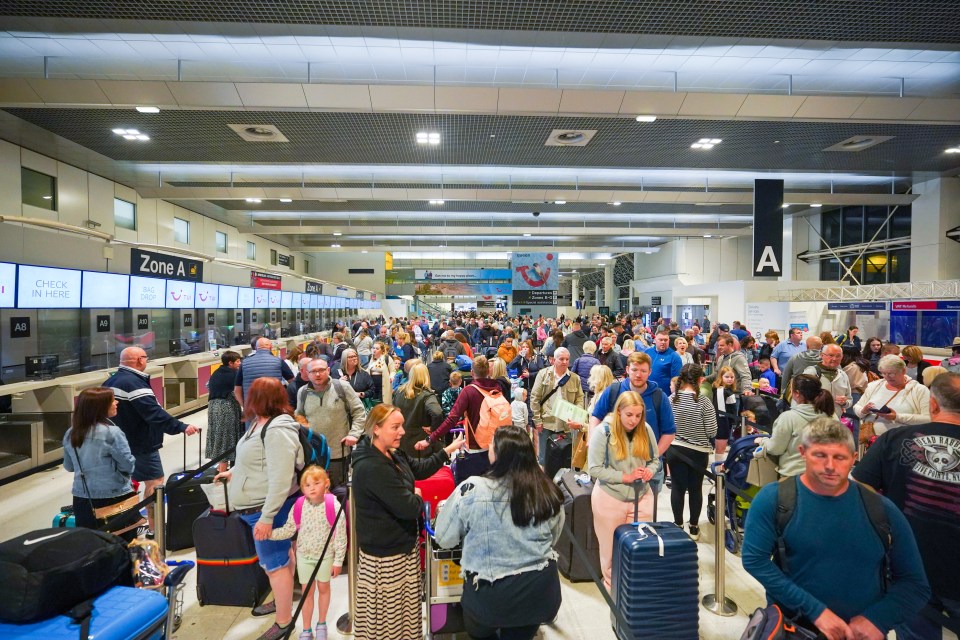 Jenny Cook said the pilot, named only as Simon, saved dozens of TUI holidays - passengers queue for check-in at Manchester Airport