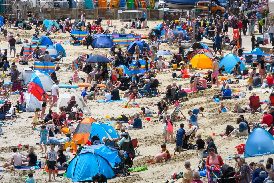 Sunseekers pack the sand in Lyme Regis, Dorset