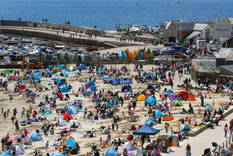 The beach is packed as sunbathers flock to the seaside resort of Lyme Regis in Dorset