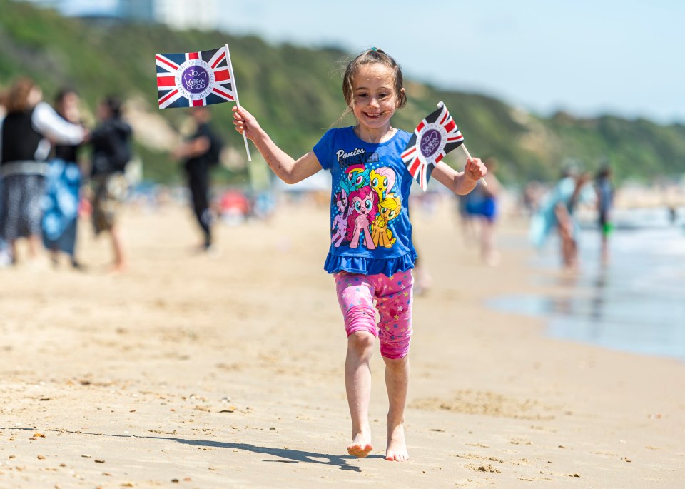 Emelia Kaszoni, six, plays along the shore in Bournemouth, Dorset