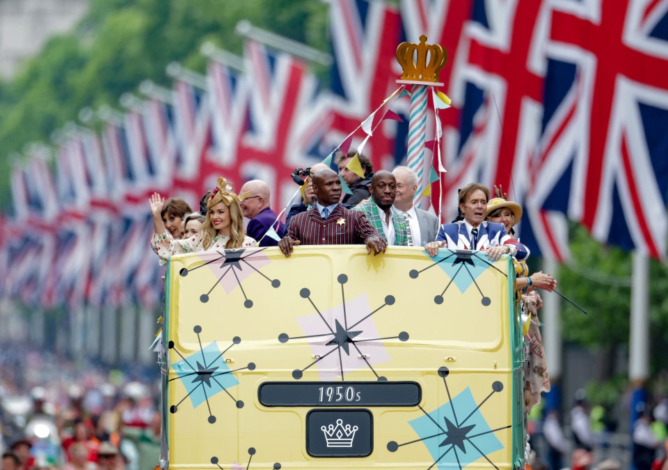 Celebrities ride a bus along the Mall as part of the procession