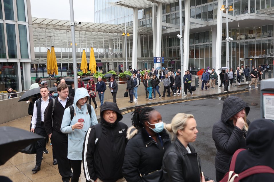 Commuters at London Bridge adorn their raincoats and umbrellas to face their Monday journeys