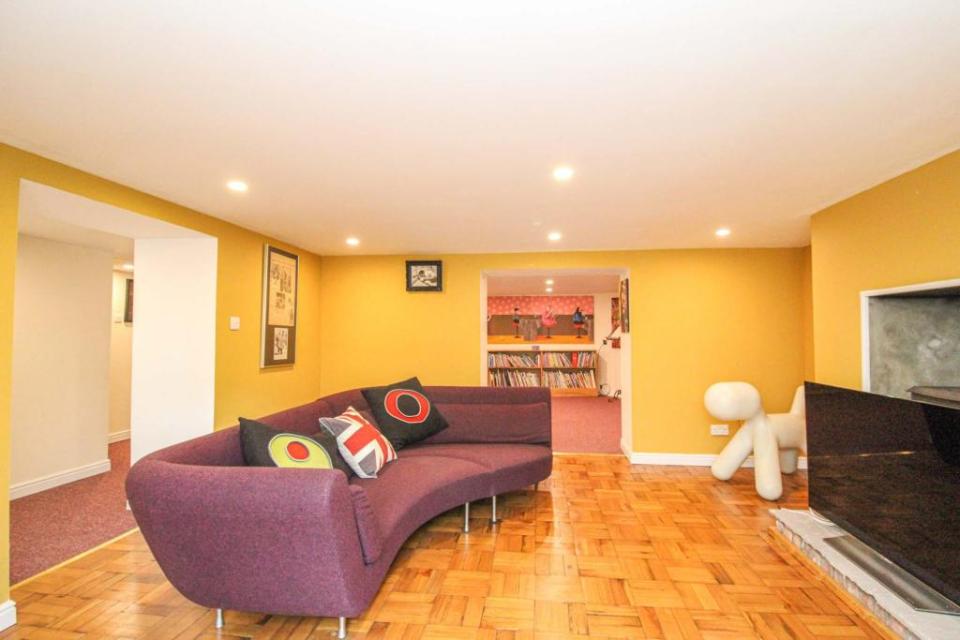 A retro snug with lemon yellow walls and a massive model dog give the occupant a funky space to kick back in front of the telly