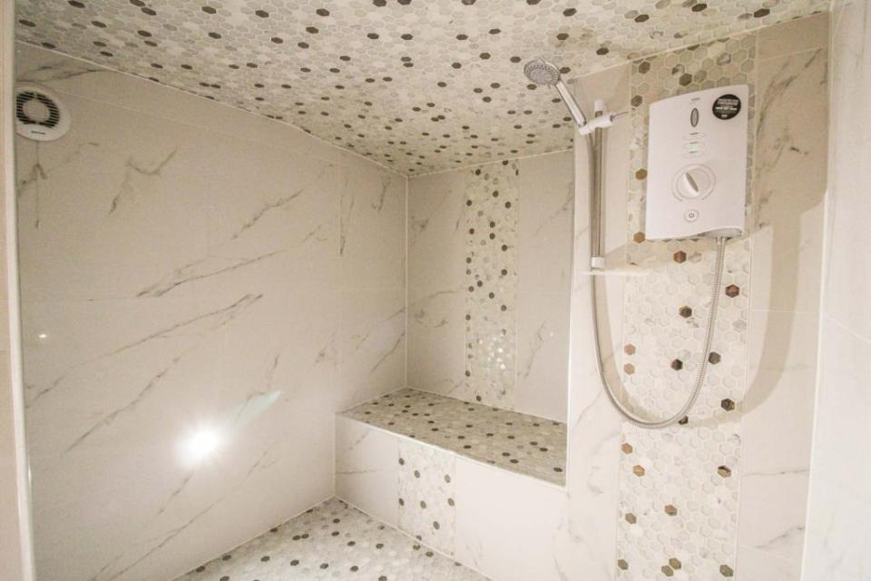 The new owners will find a gigantic marble walk-in shower room to get clean in after a long day