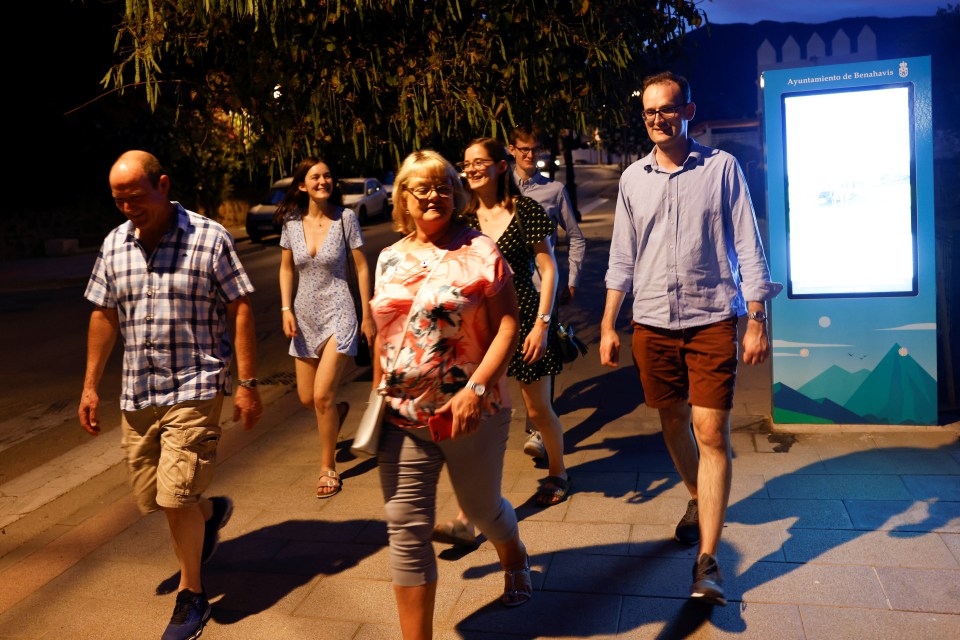 People walk as they are evacuated from the forest fire