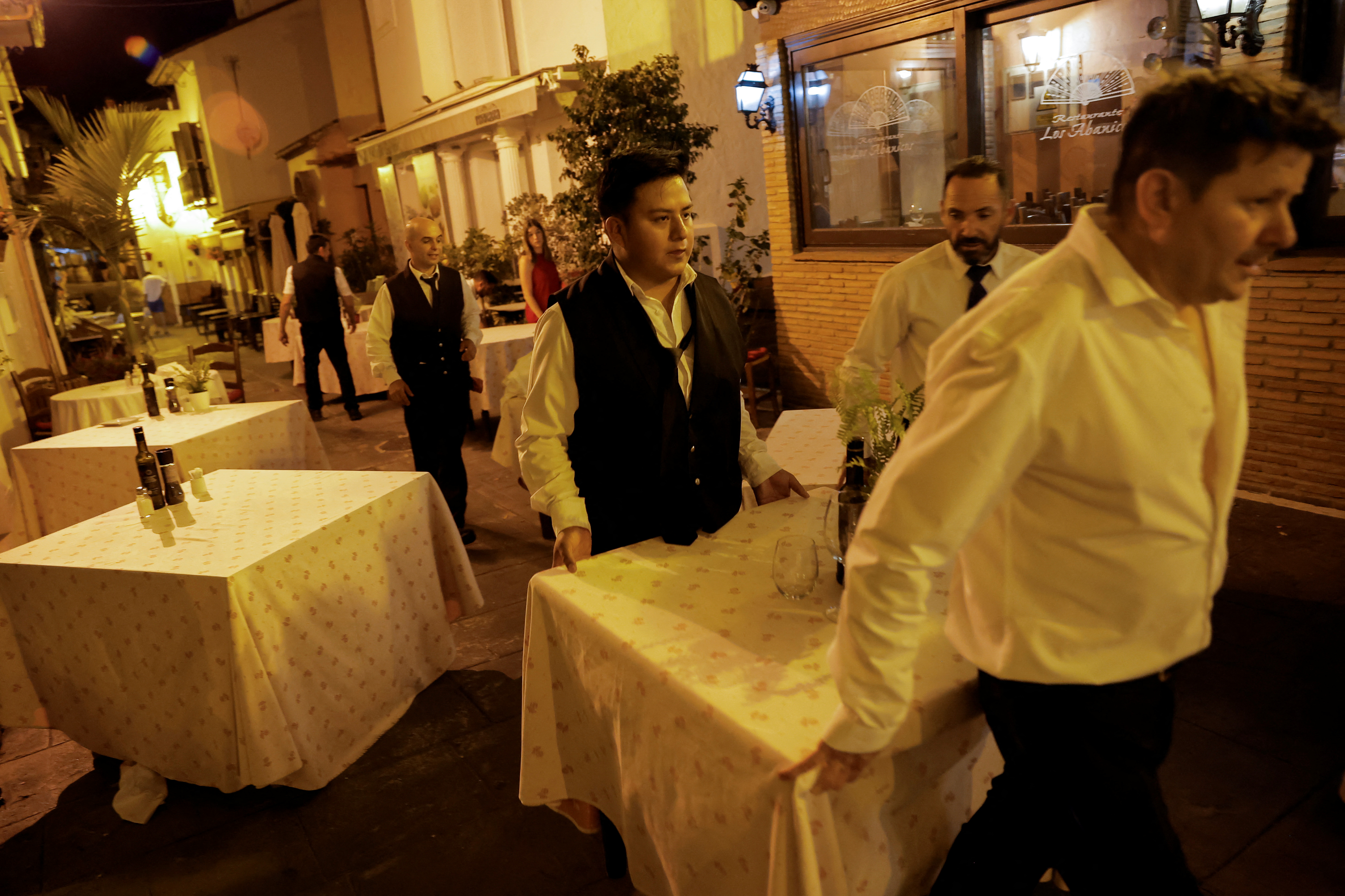 Waiters move a table from a restaurant’s terrace amid the evacuation