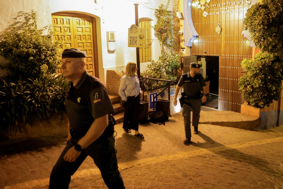 Members of the Spanish Civil Guard check a hotel as people are evacuated from a forest fire that broke out in Pujerra