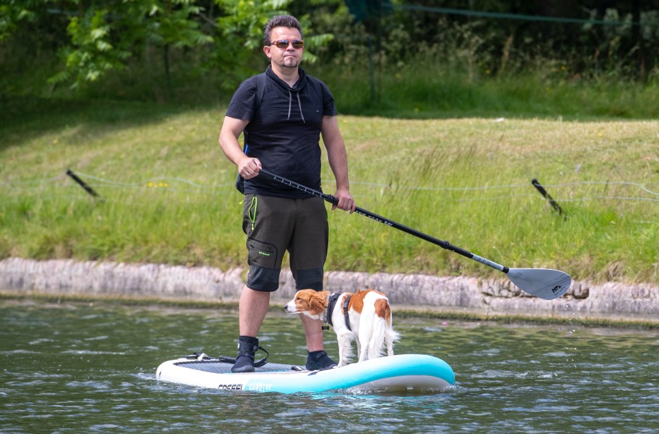 A man and his dog enjoying the warm weather today whilst out paddle boarding on the River Cam in Cambridge