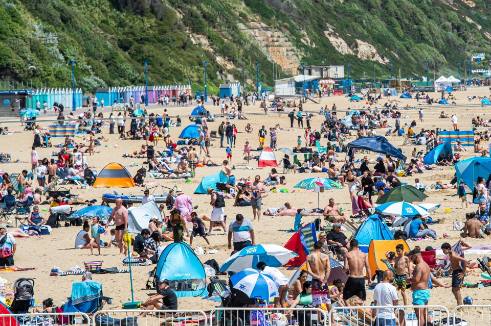 People enjoy the bright sunshine and warm weather by heading to the beach in Bournemouth, Dorset, on Saturday