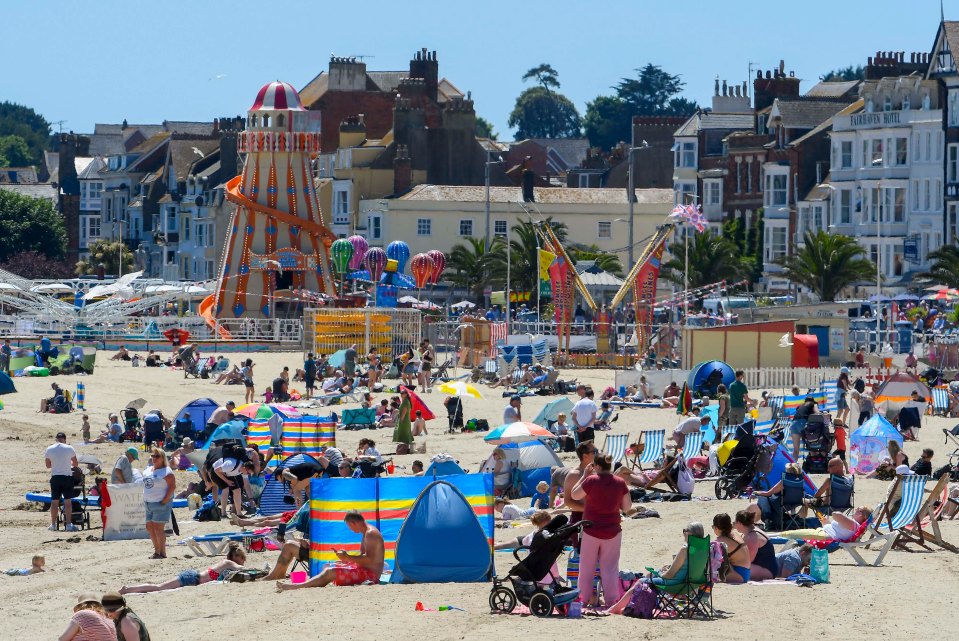 Sunbathers on a busy beach enjoying the scorching hot sunshine in Weymouth