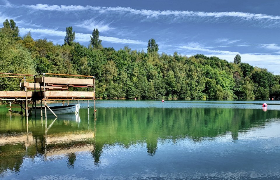 a boat is floating on a lake with trees in the background