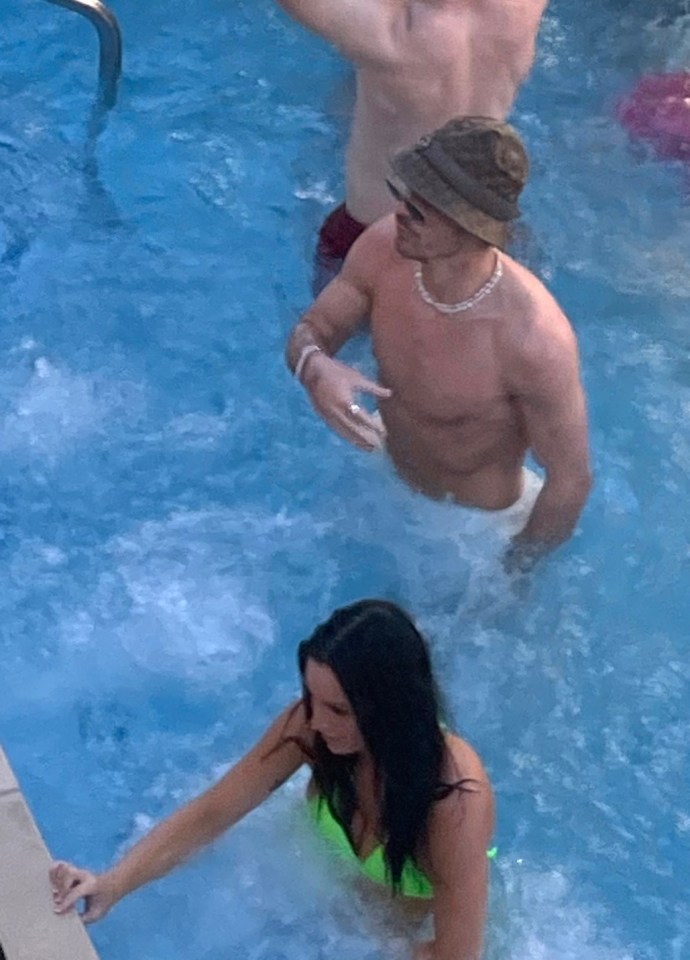 The Premier League title-winner, wearing a hat in the 33C heat, was seen swaying to music in the pool