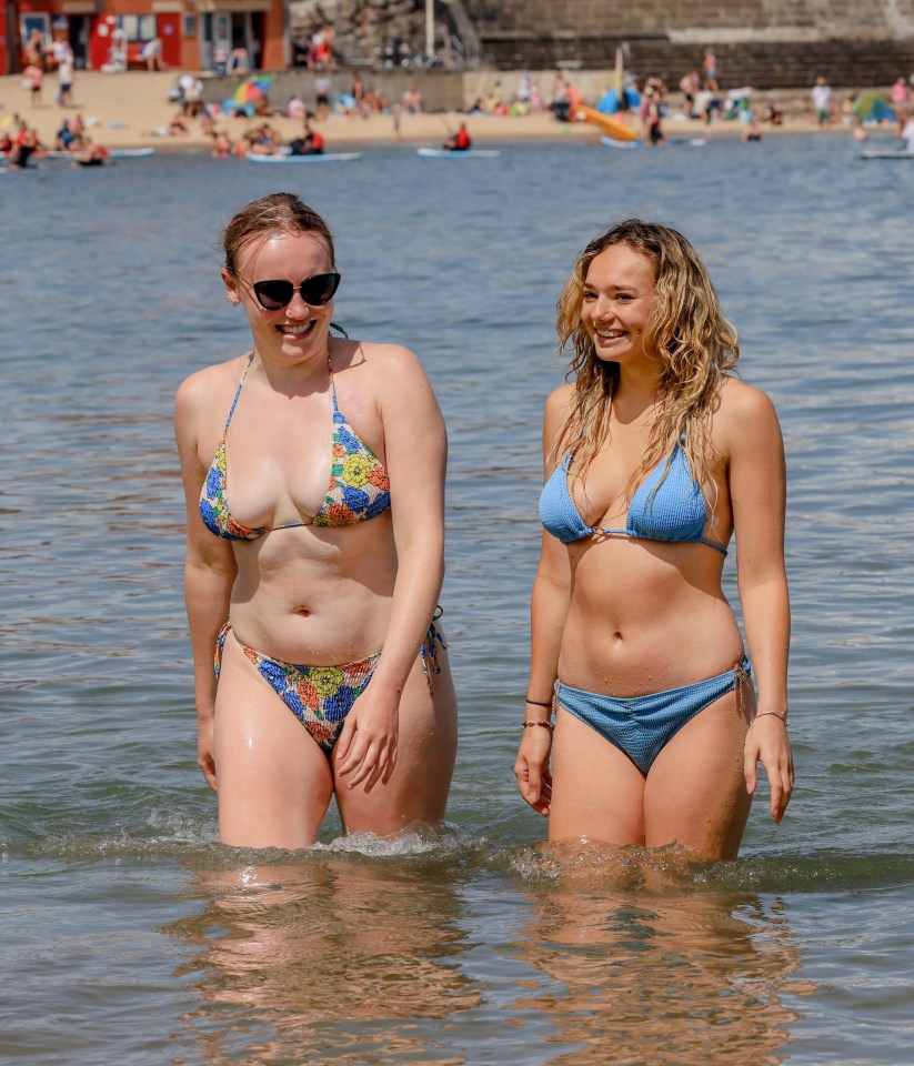 Pals Amy Villamore, right, and Hannah Brown take a cooling dip in the sea at Cullercoats Bay in North Tyneside