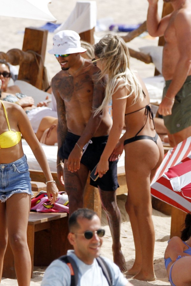 The stunning couple giggled on the beach as they soaked up the sun