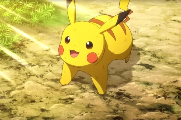 a pikachu is standing on a dirt road in the grass .