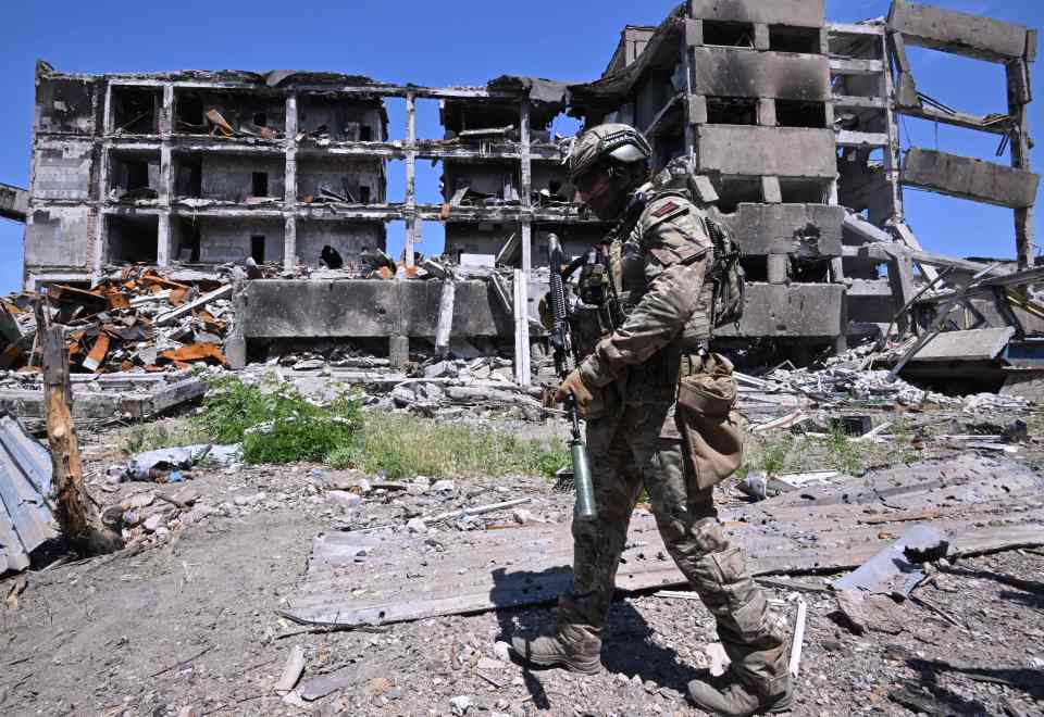 A Russian serviceman stands guard in an area near the Azovstal steel plant in Mariupol on June