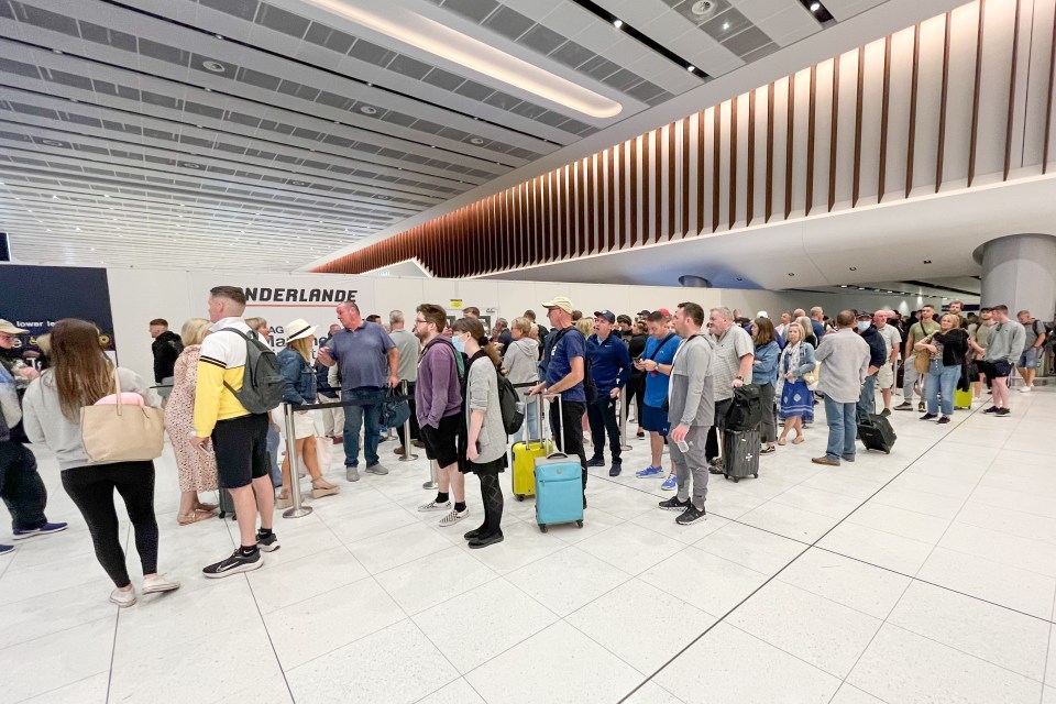 Passengers queue for security at Manchester Airport Terminal 2