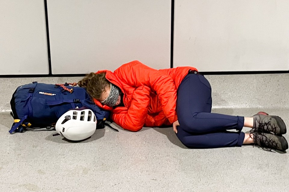 A passenger sleeps on the floor at Manchester Airport