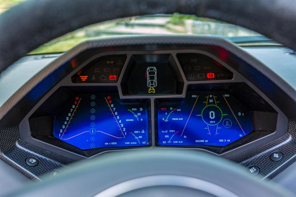 The car's digital instrument cluster includes a G-force meter