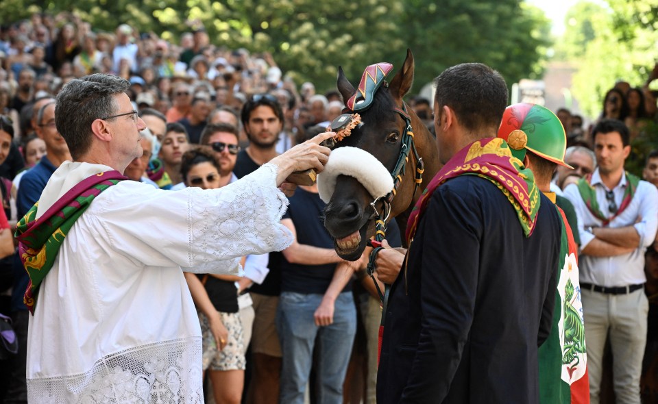 The winning horse and jockey are blessed before taking part in the race