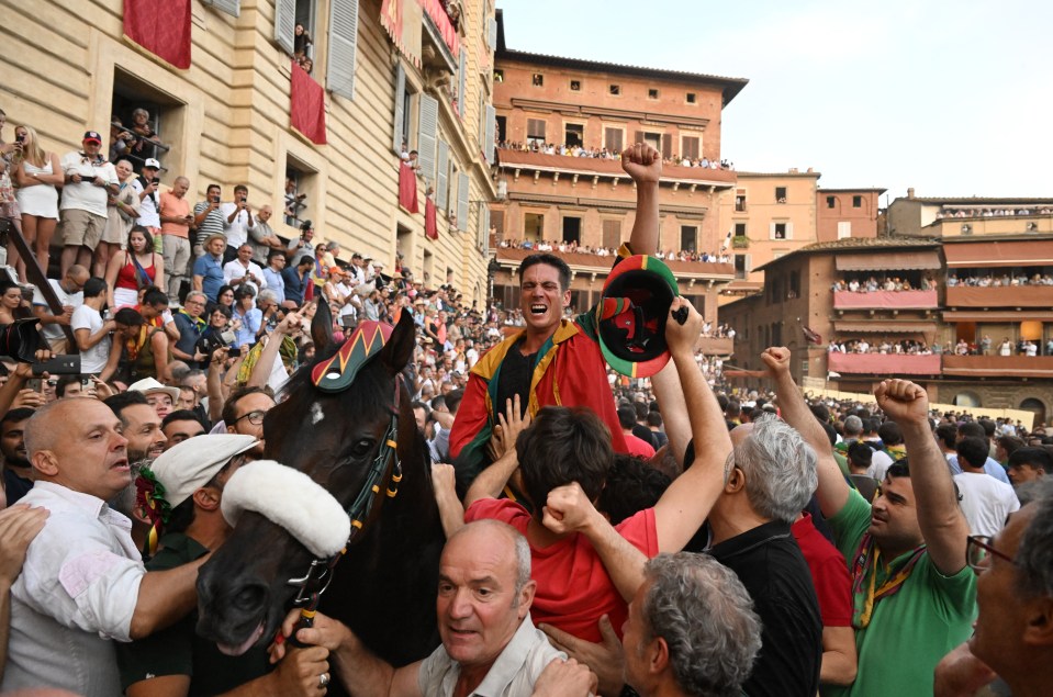 Jockey Giovanni Atzeni celebrates after winning the Palio aboard his horse Zio Frac