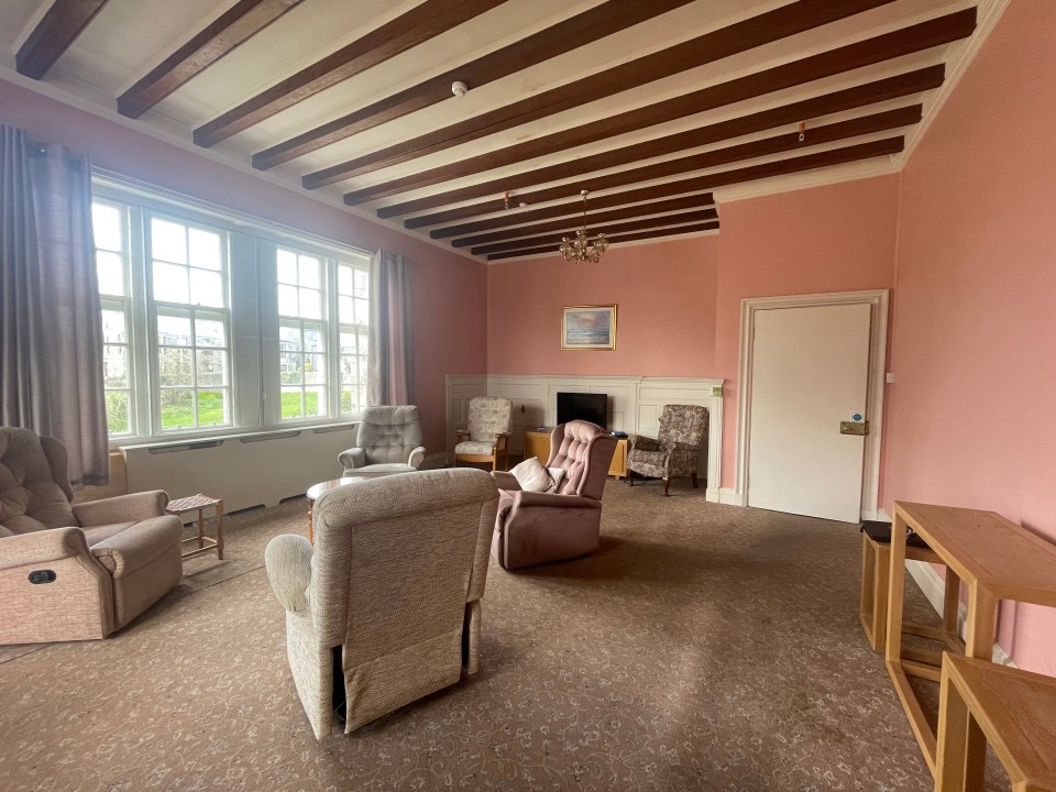 The property's living room with large windows and a beamed ceiling