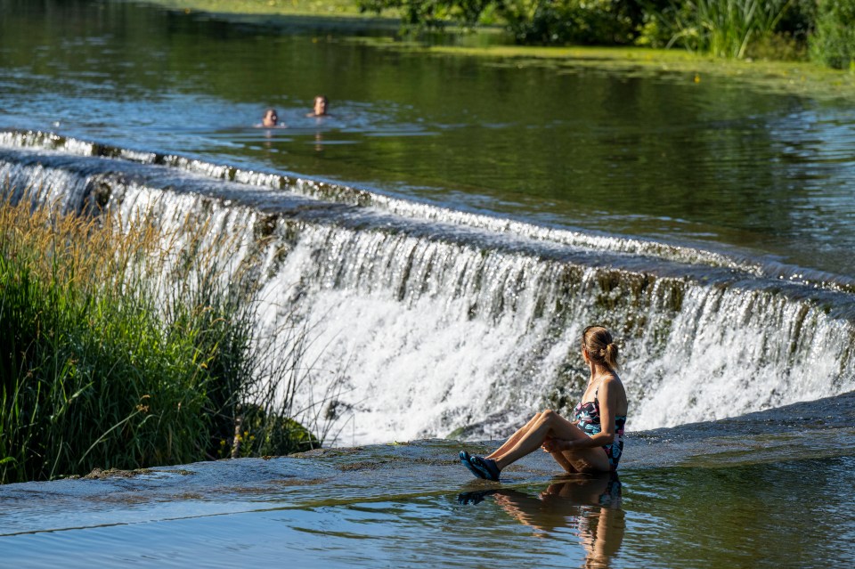 Visitors waded into Warleigh Weir near Bath in Somerset yesterday