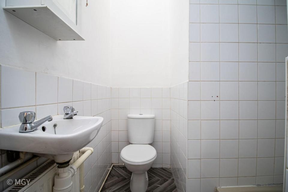 The toilet, sink and shower are all within touching distance of each other in the cramped bathroom