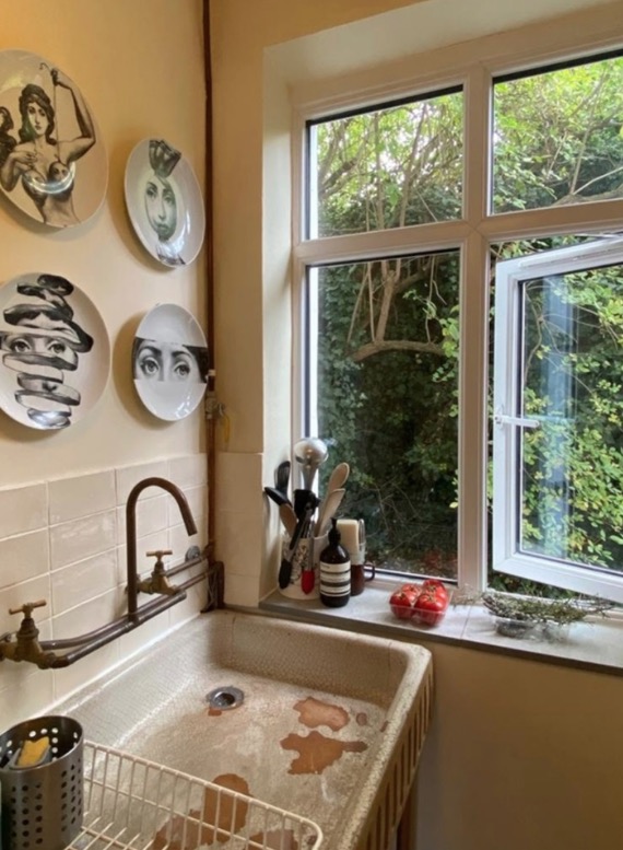 Inside, the galley kitchen features a lovely old-school sink