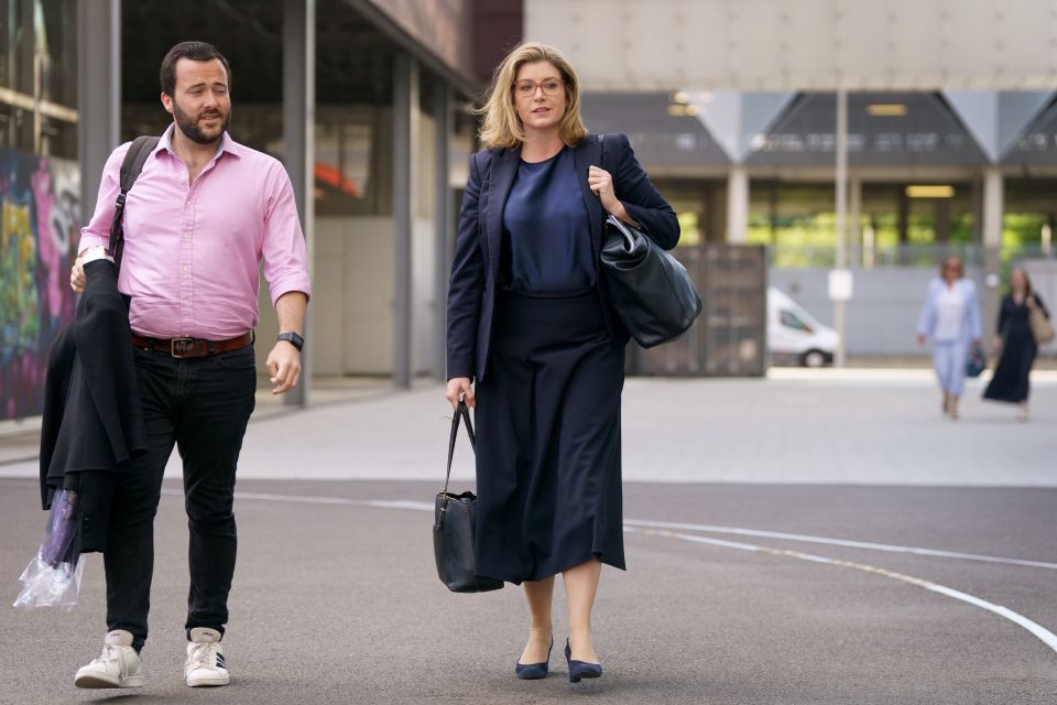 Penny Mordaunt arrives at last night's debate with an aide