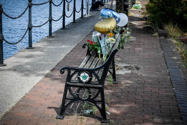 Flowers at a bench left as a tribute to the lad who drowned