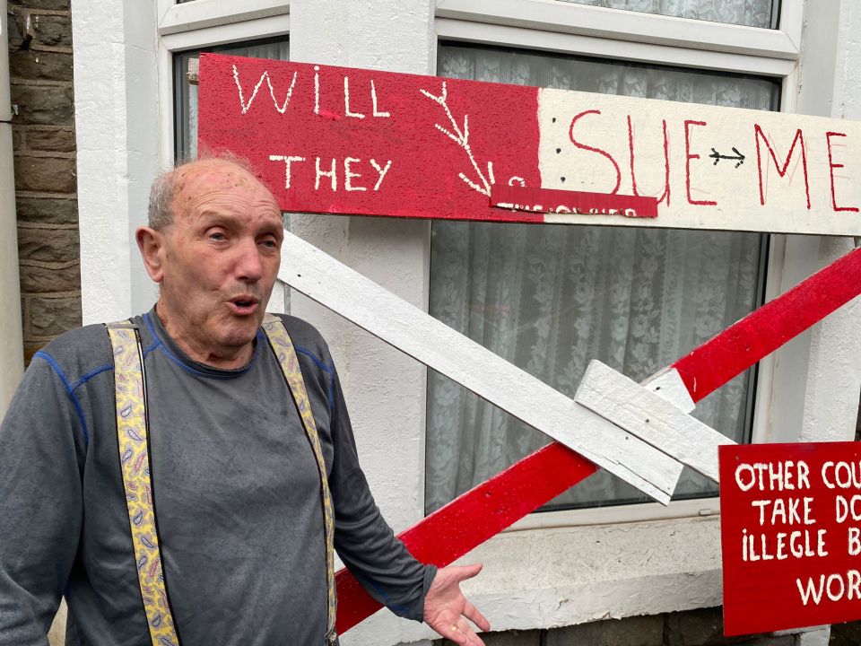 Ewen Taylor set up a series of signs in his front garden after alleging his neighbours had built onto his land during work on an extension to their home in 2020